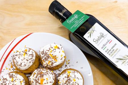 Dolcetti con panna e scorza d'arancia accanto a olio extravergine d'oliva.